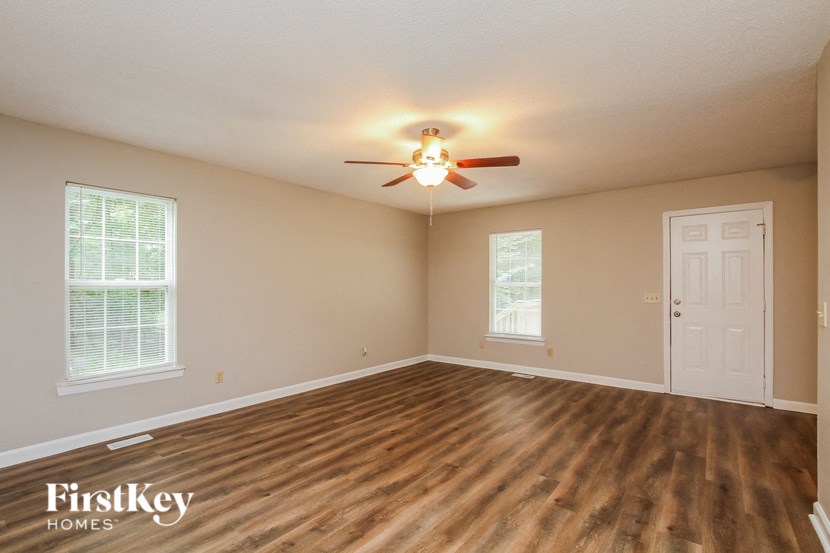 A room with a ceiling fan and wooden flooring.