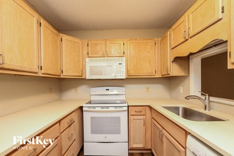 A kitchen with wooden cabinets and a white dishwasher.