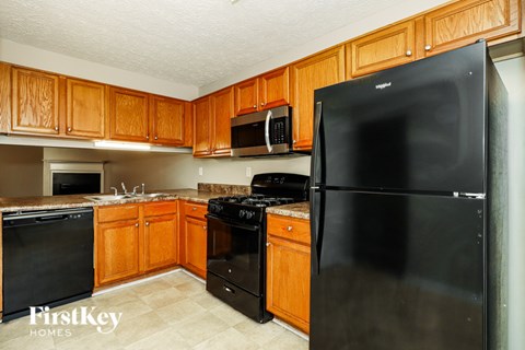 A kitchen with wooden cabinets and black appliances.