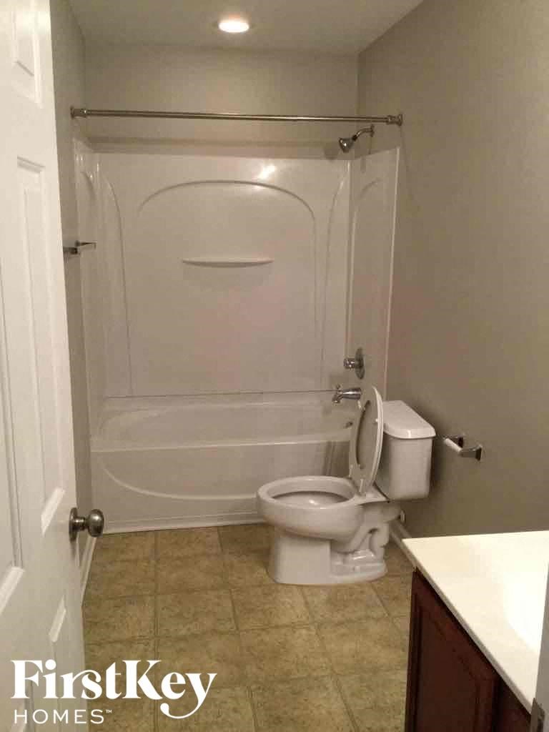 A white bathroom with a toilet and a walk in shower.
