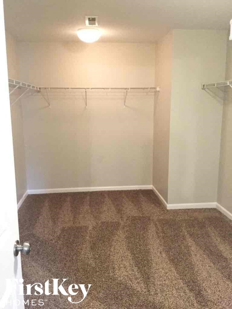 A room with a carpeted floor and a white door.