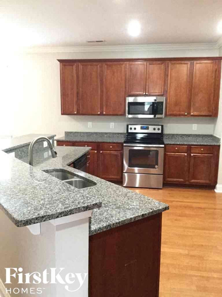 A kitchen with granite countertops and wooden cabinets.
