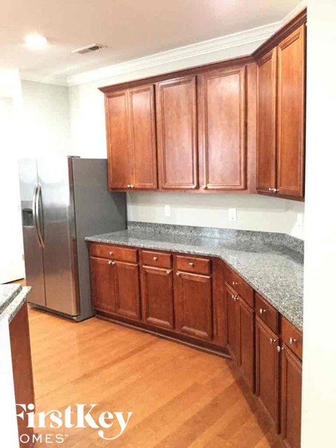 A kitchen with wooden cabinets and a granite countertop.