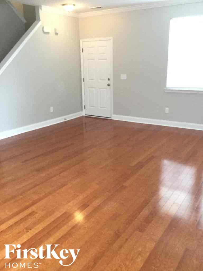 A room with wooden flooring and a white door.