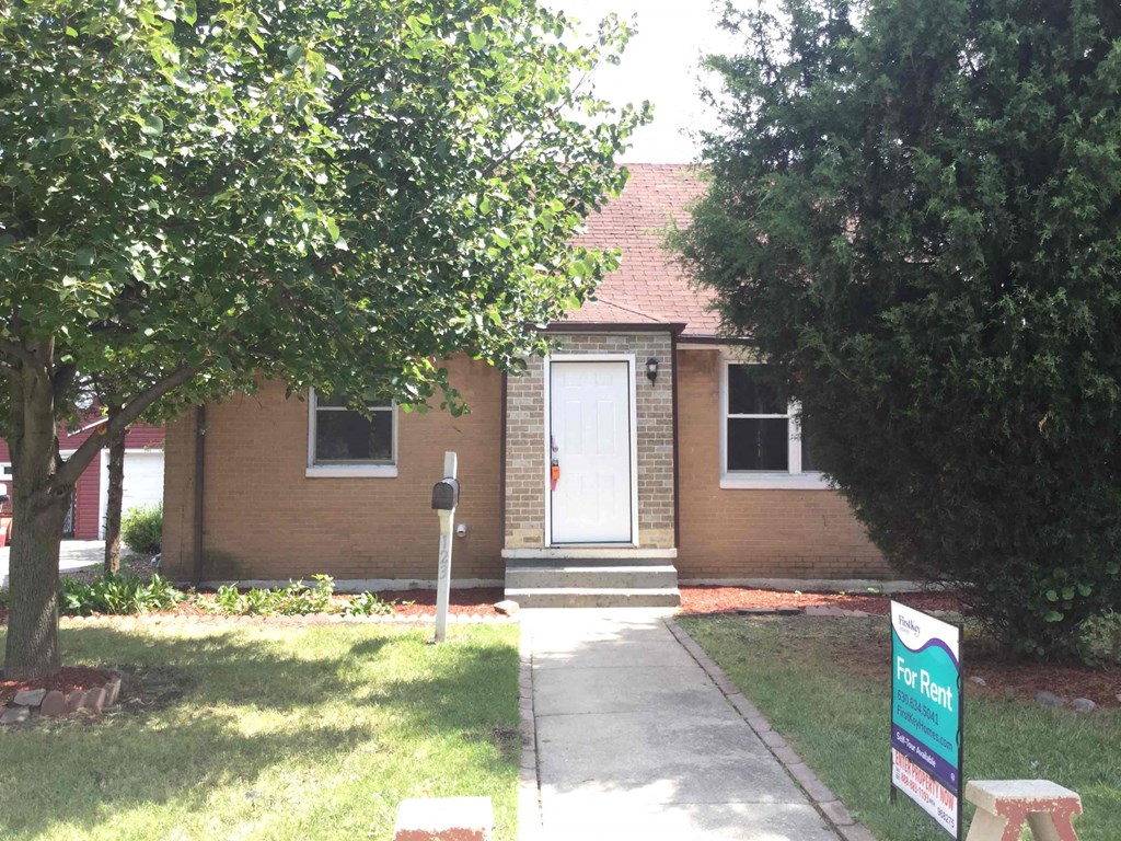 A house with a For Rent sign in front.