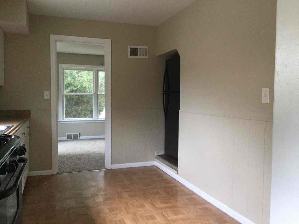 A room with a door leading outside and a flat screen TV mounted on the wall.