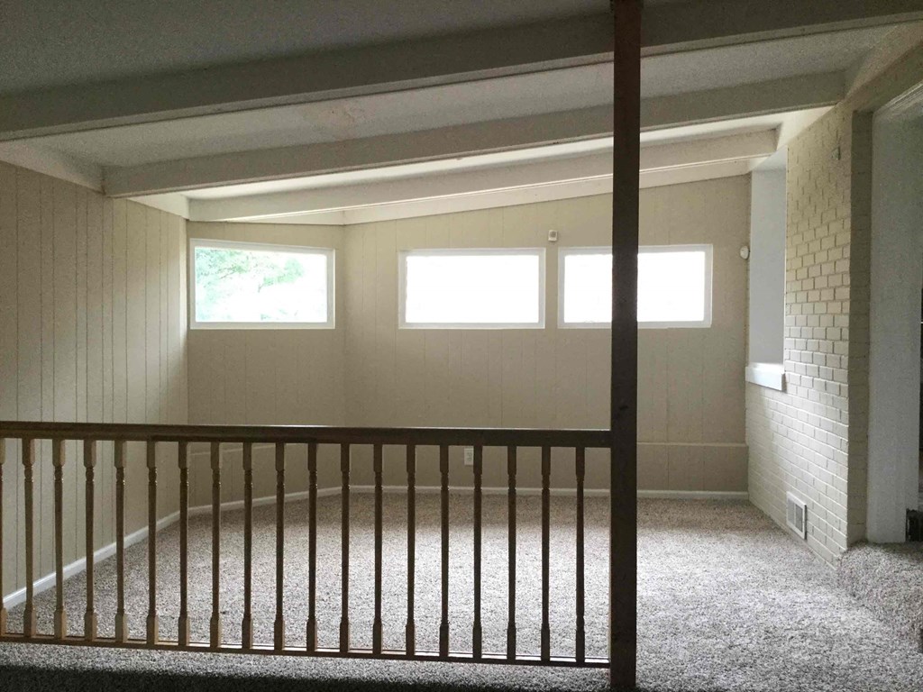 A room with a carpeted floor and a window.