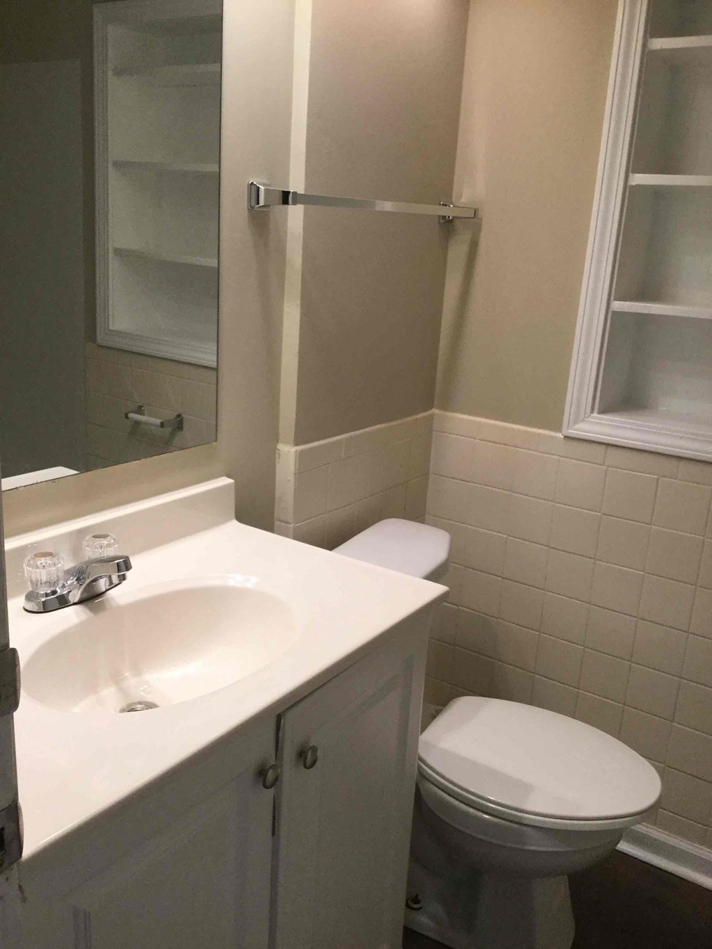A white toilet sits next to a white sink in a bathroom.
