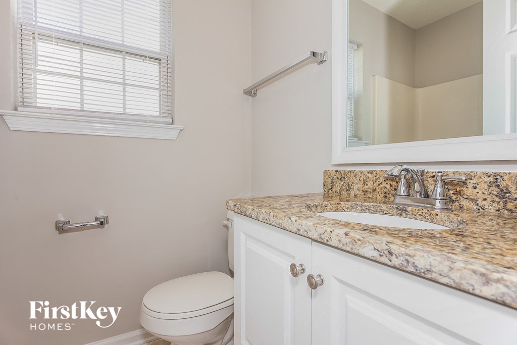 a bathroom with a toilet and a sink and a mirror