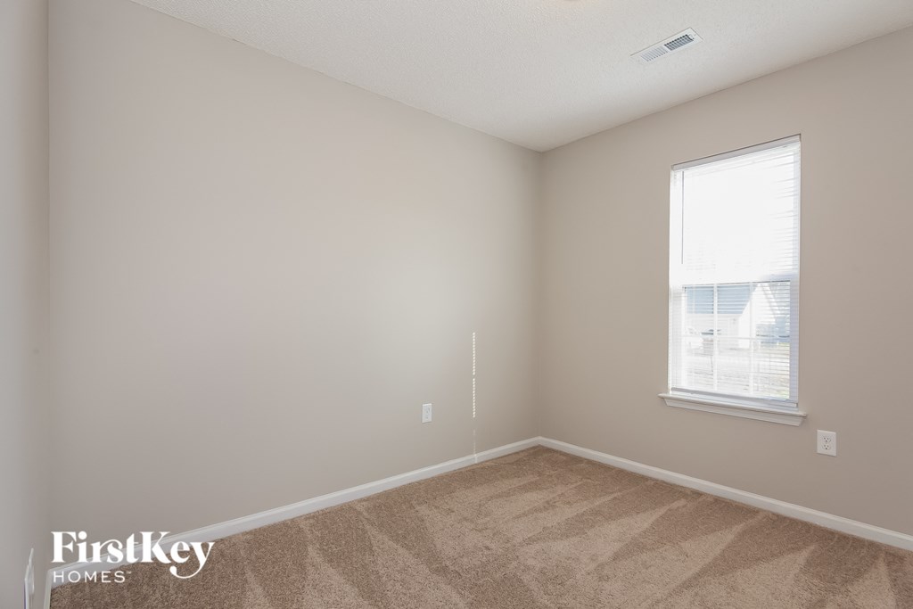 a bedroom with carpet and a window