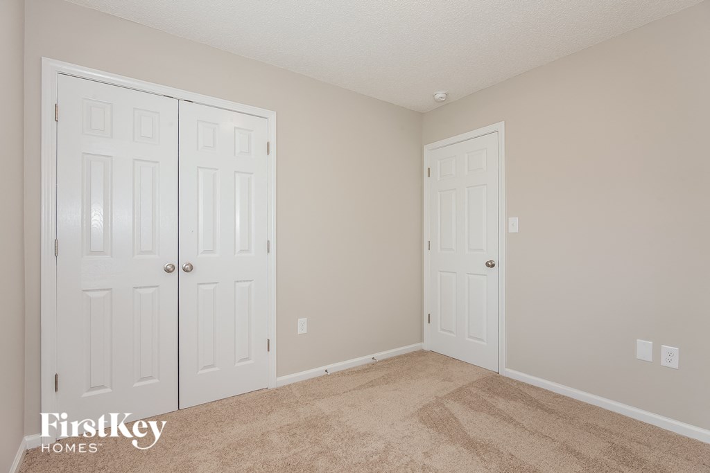 a bedroom with two closets and two doors