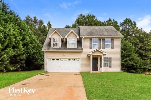 a tan house with a white garage door