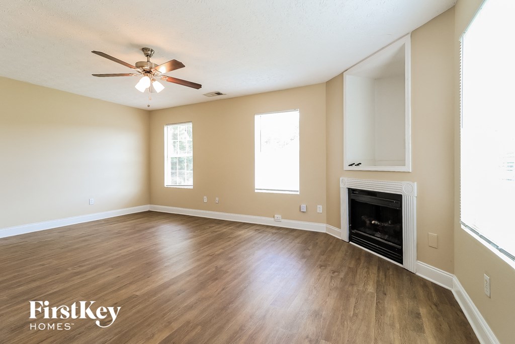 a living room with a fireplace and a ceiling fan