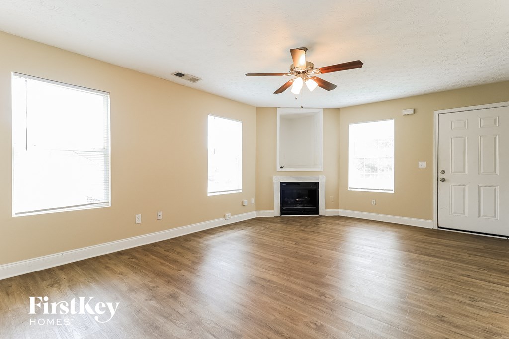 a living room with wood floors and a ceiling fan