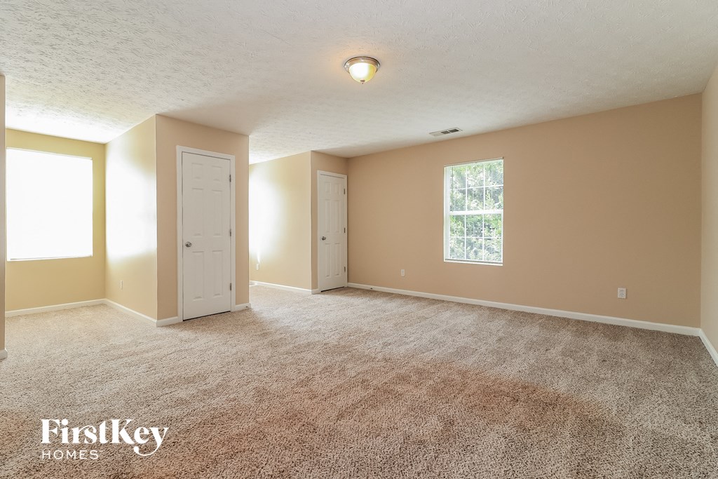 the living room of an empty house with carpet and a door