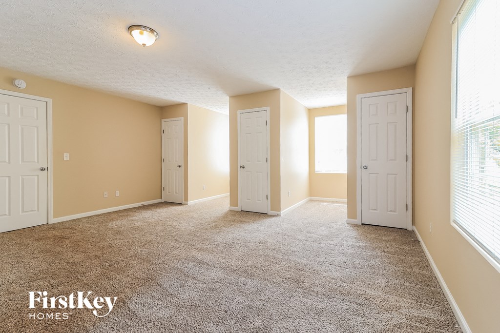 an empty living room with two doors and a window