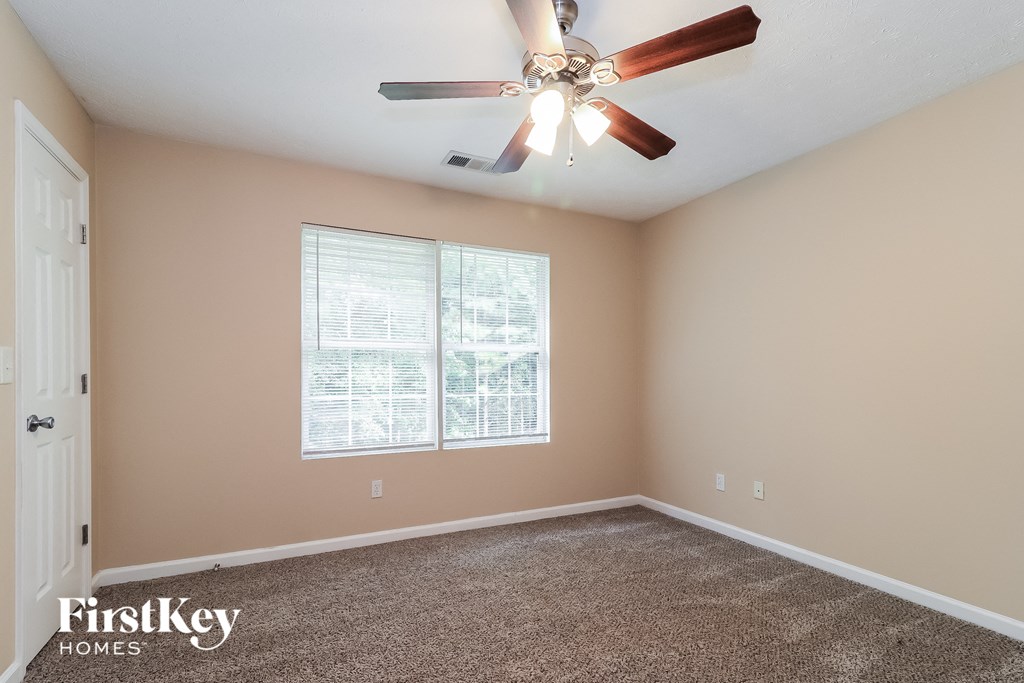 a bedroom with a ceiling fan and a window