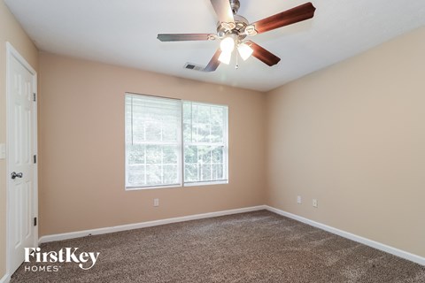 a bedroom with a ceiling fan and a window
