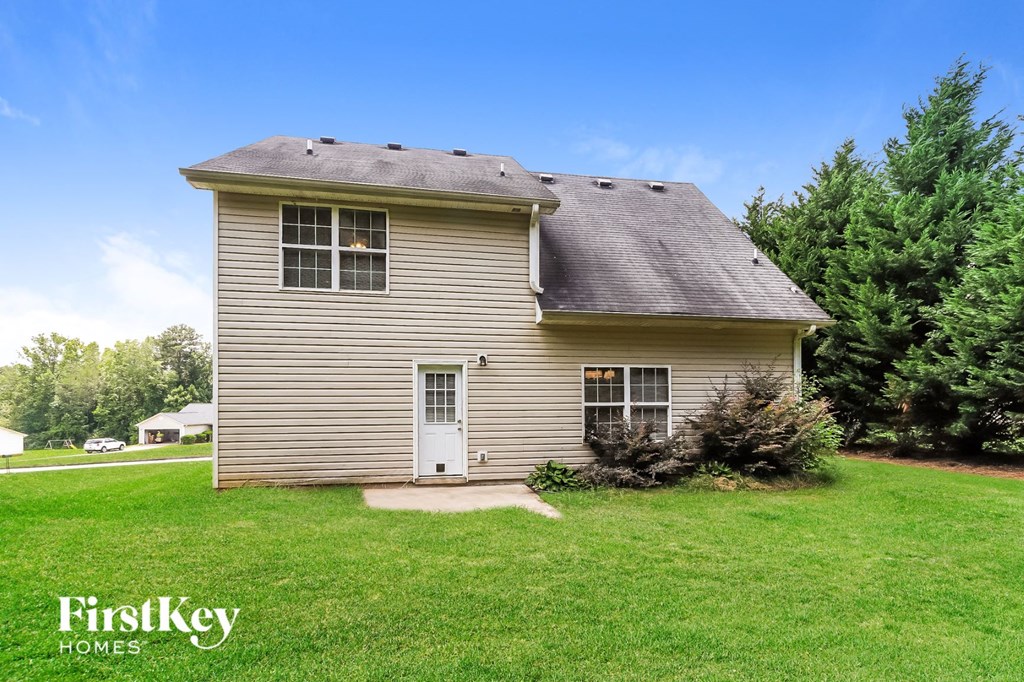 a small yellow house with a white door and a green lawn
