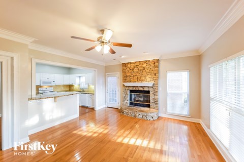 A living room with a fireplace and a ceiling fan.