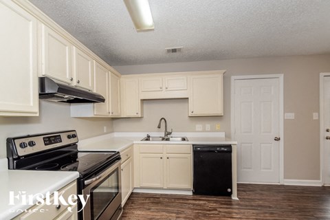 A kitchen with white cabinets and a black dishwasher.
