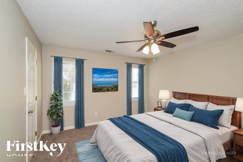 A bedroom with a large bed and a ceiling fan.