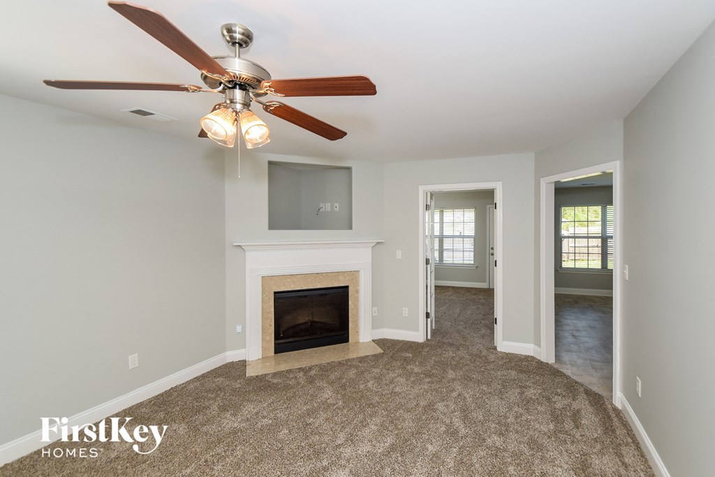 A room with a fireplace and a ceiling fan.