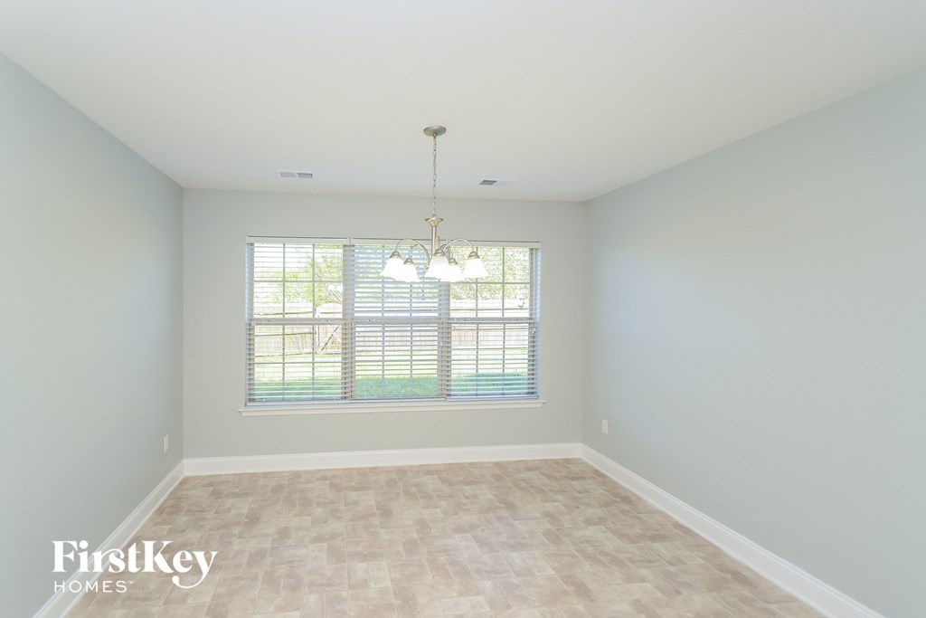 A room with a window and a chandelier.
