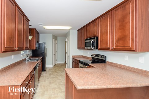 A kitchen with brown cabinets and a brown counter top.