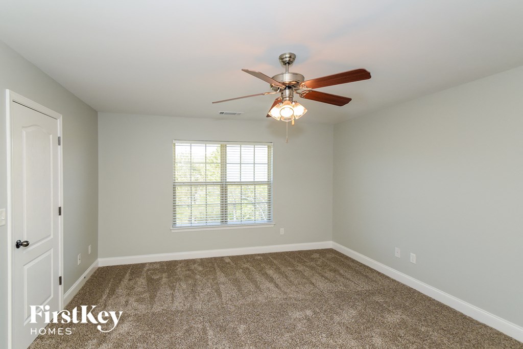 A room with a fan and a window.