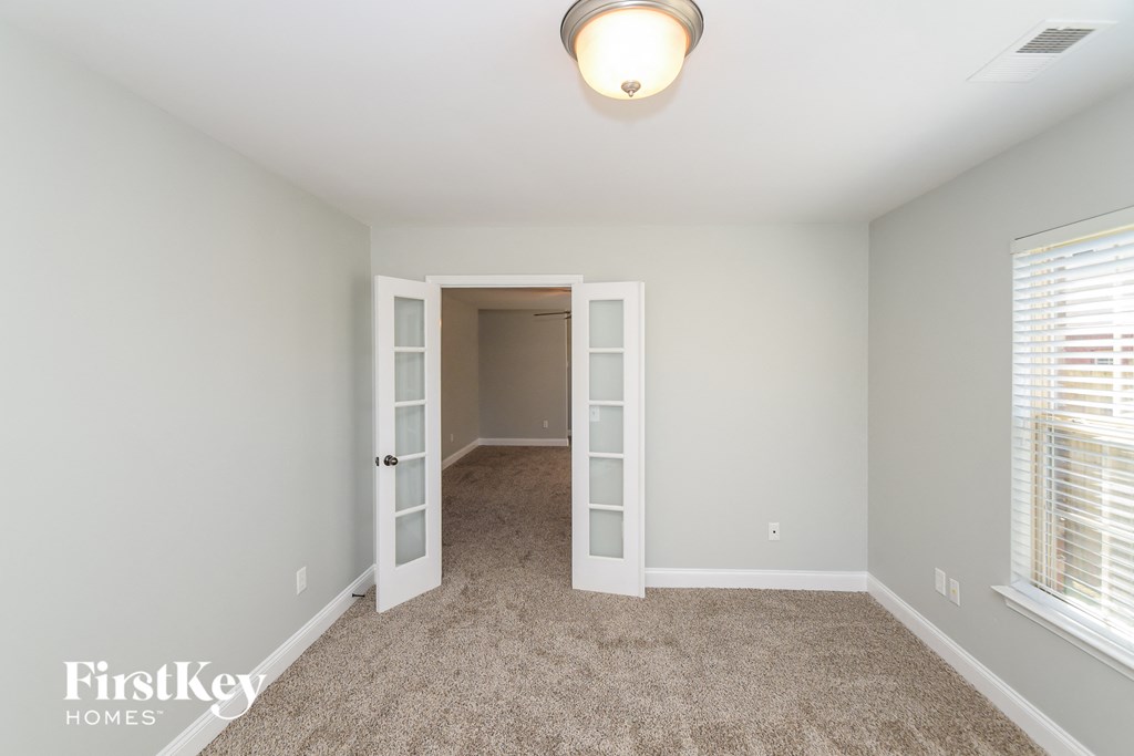 A room with a carpeted floor and a doorway leading to another room.
