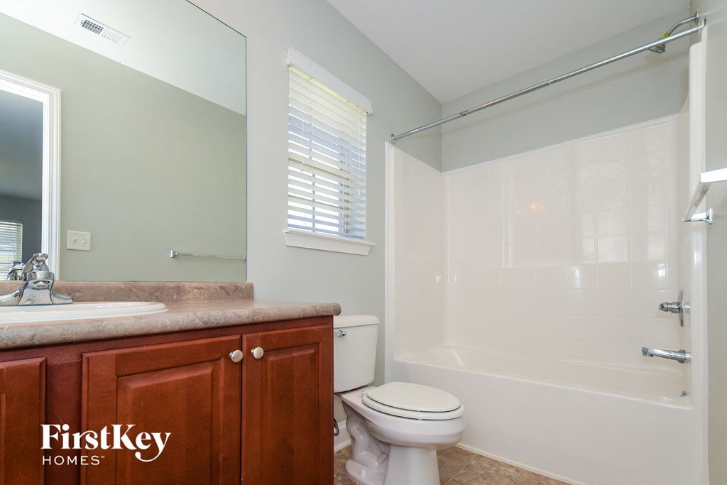 A bathroom with a toilet, sink, and bathtub.