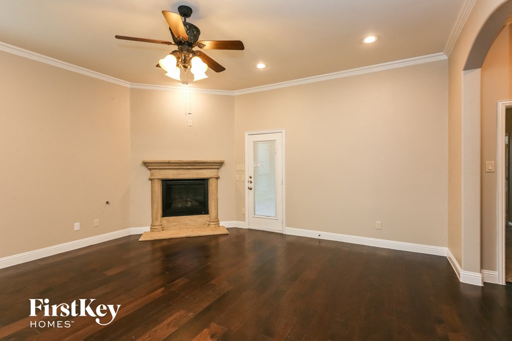 a living room with a fireplace and a ceiling fan