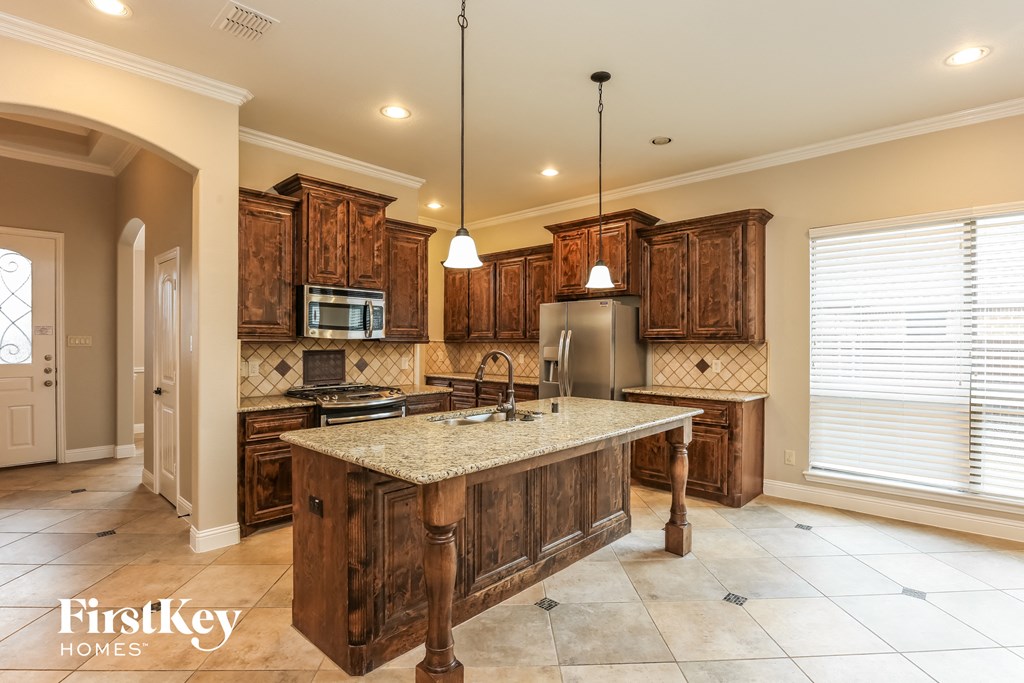 a kitchen with wooden cabinets and a granite counter top
