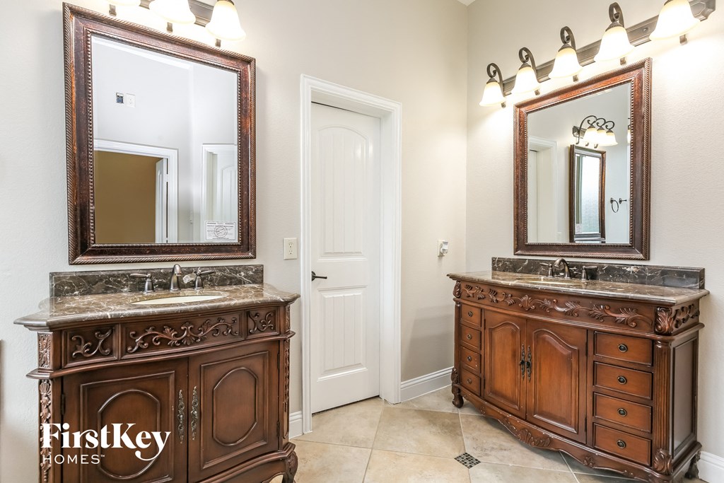a bathroom with two sinks and two mirrors
