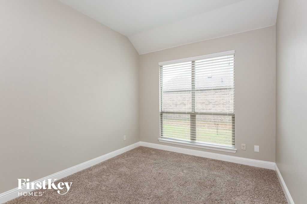 a bedroom with a large window and carpet