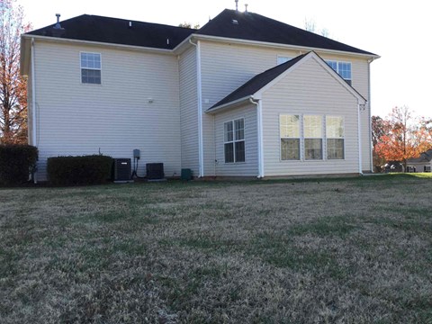 A house with a white siding and a black roof.
