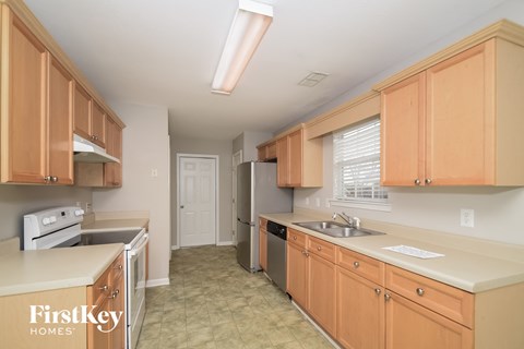 A kitchen with wooden cabinets and a stove top oven.