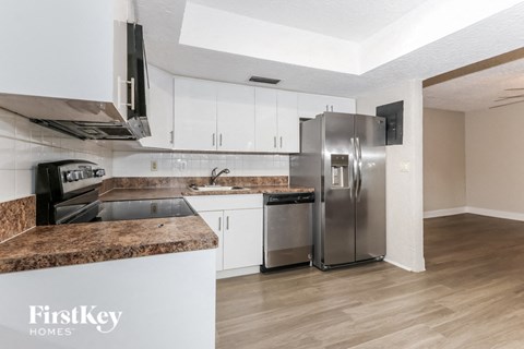 A kitchen with a granite counter top and stainless steel appliances.