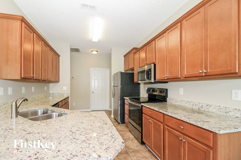 a kitchen with wood cabinets and granite counter tops and black appliances
