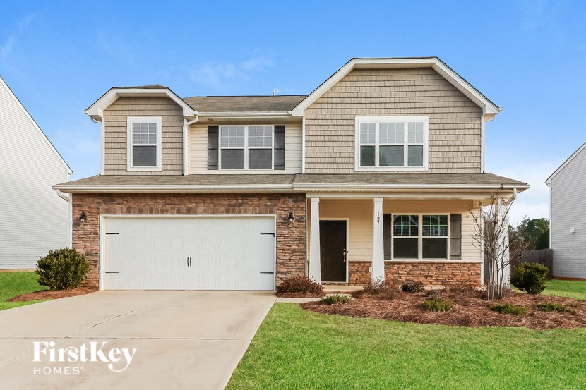 A two-story house with a garage is for sale.