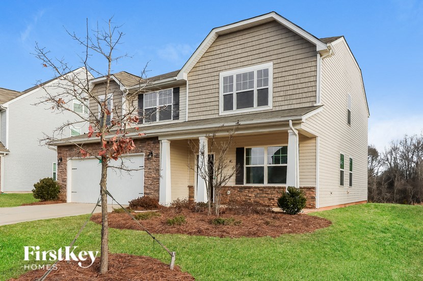 A house with a tree in the front yard.