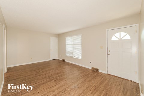 a living room with a wooden floor and a white door