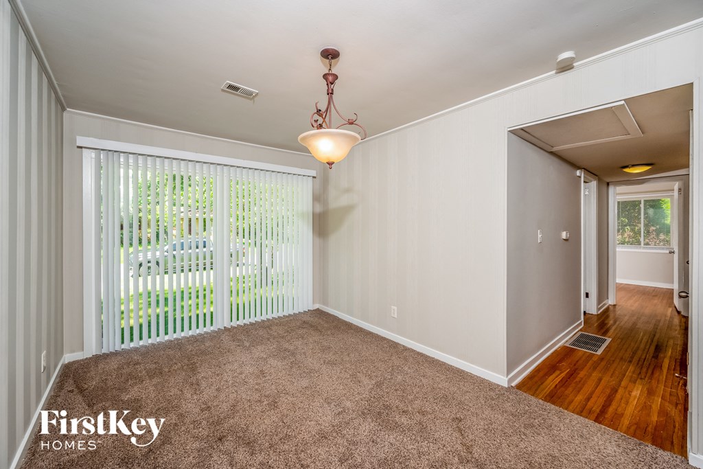 A room with a carpeted floor and a sliding glass door.