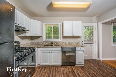 A kitchen with white cabinets and a granite countertop.