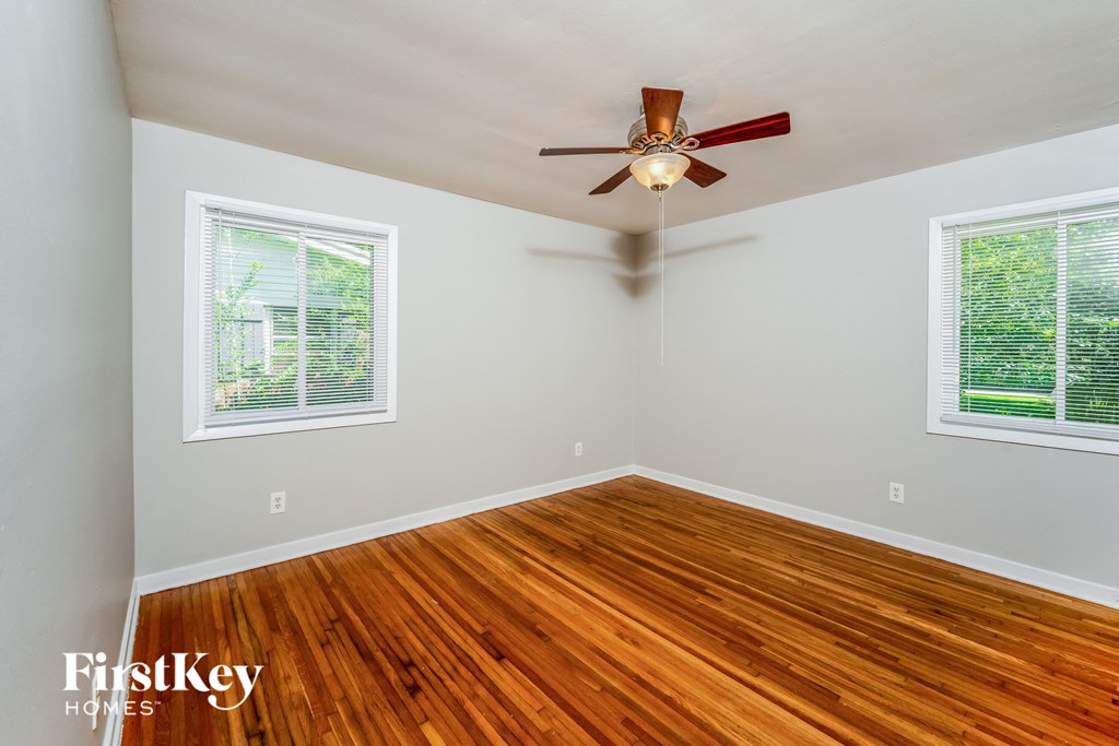 A room with wooden floors and a ceiling fan.