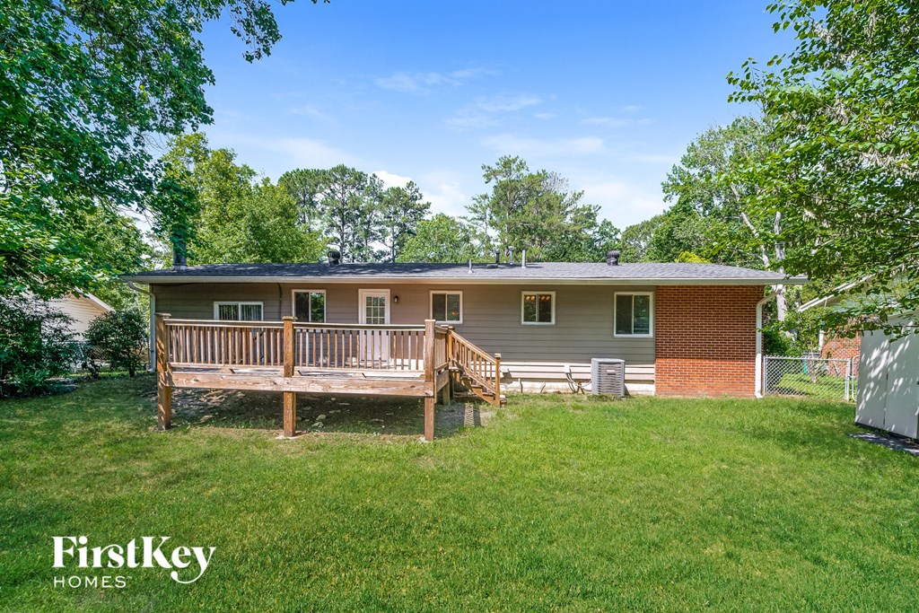 A house with a porch and a fence in the yard.