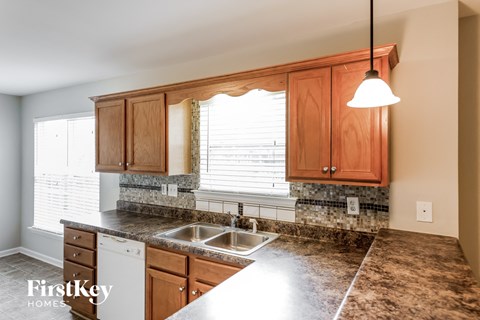 A kitchen with wooden cabinets and a granite countertop.