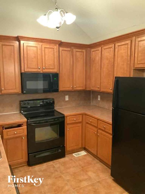 A kitchen with wooden cabinets and black appliances.