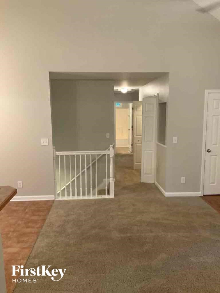 A room with a carpeted floor and a white door.